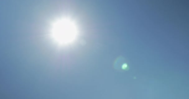 Перемещение от солнца к солнечным панелям против голубого чистого неба — стоковое видео