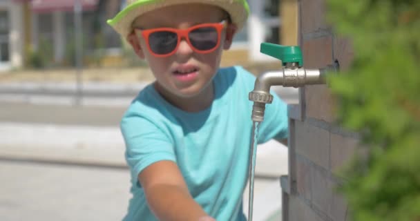 Niño lavándose las manos en el grifo de la fuente en lugar público en el día de verano Pireo, Grecia — Vídeos de Stock