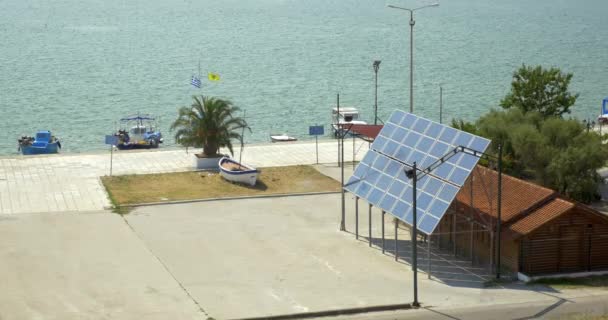 Paneles solares se fijan al lado de la casa, en el fondo es un mar tranquilo — Vídeos de Stock