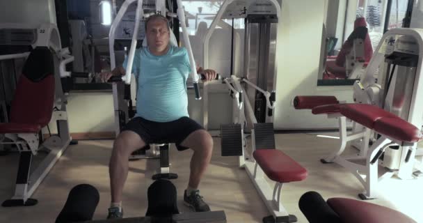 Volwassen man in sportschool voert oefeningen borstpres — Stockvideo
