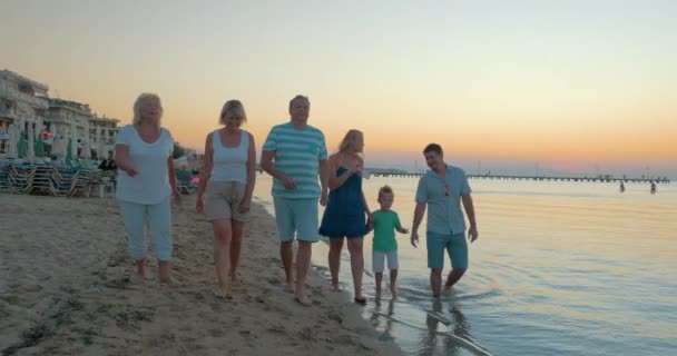 Μεγάλη χαρούμενη αστεία οικογένεια βόλτες στην παραλία στο ηλιοβασίλεμα θάλασσα Πειραιάς, Ελλάδα — Αρχείο Βίντεο
