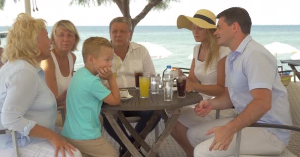 Stor familj sitter vid bordet på havskusten i staden Perea, Grekland — Stockvideo