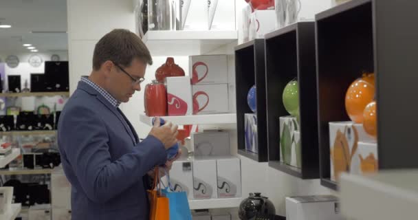 In store of Thessaloniki, Greece man choose kettle — Stock Video