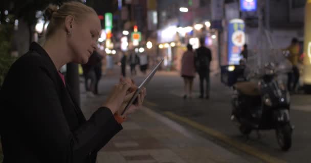 Woman working with pad in night Seoul street, South Korea — Stock video