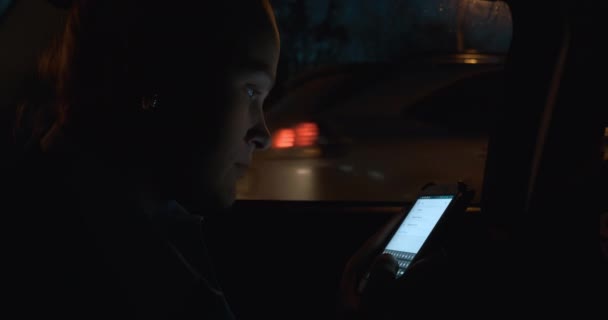 Mujer con teléfono inteligente en coche por la noche — Vídeo de stock