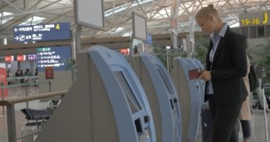 Giriş yapmak için self-servis makinesini kullanan kadın
