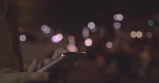 Kobieta wiadomości tekstowe na telefon komórkowy w nocy miasto z Hanoi, Wietnam — Wideo stockowe