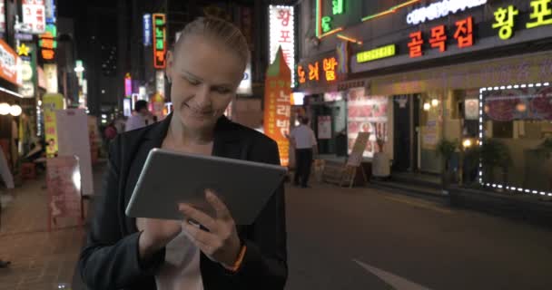 Vrouw met behulp van touchpad in de straat van Seoel 's nachts, Zuid-Korea — Stockvideo