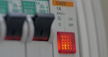 Woman finger turns on electricity switch and button is lighting