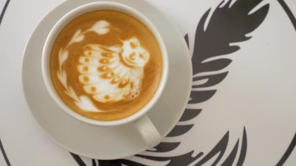 Table is served with a cup of coffee with foam and a drawing, then put sugar in cup — Stock Video