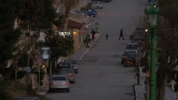 В греческом городе Неа-Каллистия появилась тихая улица с припаркованными машинами и деревьями — стоковое видео