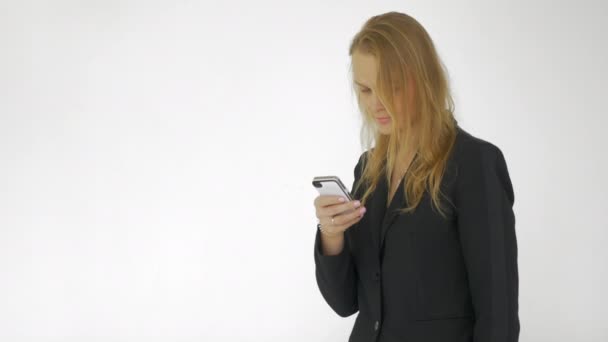 En el estudio una chica joven trabajando en un teléfono móvil — Vídeos de Stock