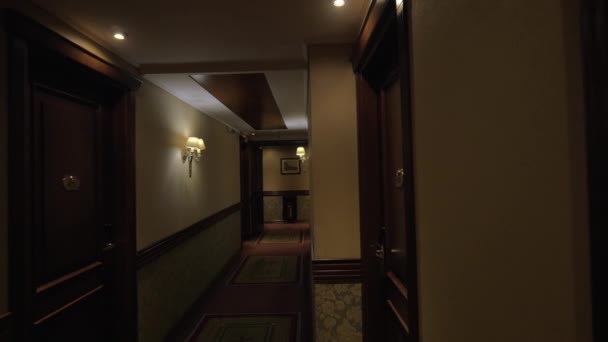 Vu long couloir de l'hôtel avec des lumières brillantes et des portes des chambres 