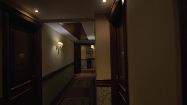 Seen long hotel corridor with glowing lights and doors from the rooms — Stock Video