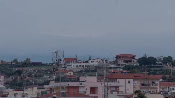 Timelapse em Nea Kallikratia, Grécia ao pôr do sol visto telhados de casas com antenas e monte Olimpo — Vídeo de Stock