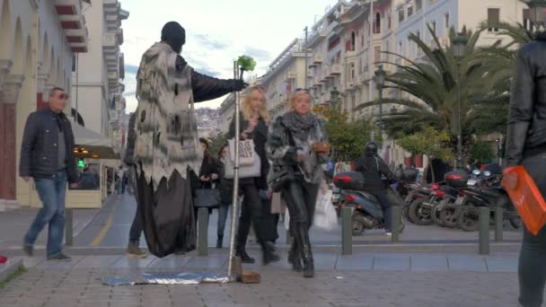 Bei sonnigem Wetter zeigt ein Straßenkünstler im Kostüm des Todes einen Trick, wie man in der Luft fliegt — Stockvideo