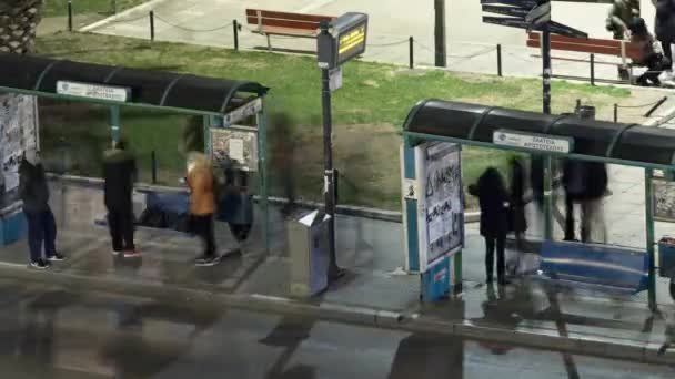 Timelapse de la ciudad de la noche con la parada de autobús, donde esperan a la gente del transporte — Vídeos de Stock