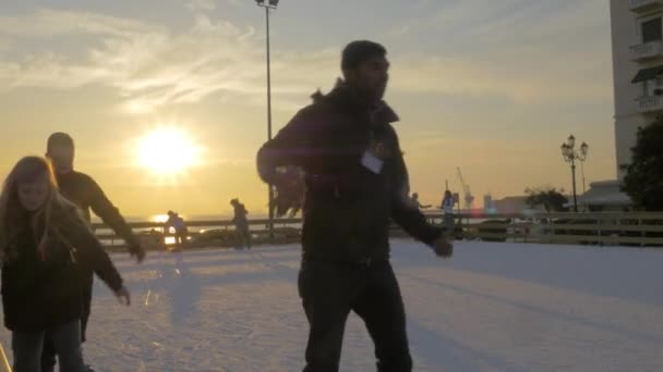 Bei sonnigem Tag auf der Eisbahn am aristotelischen Platz Schlittschuhlaufen Kinder und Jugendliche — Stockvideo