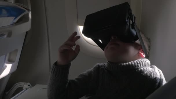 Kind met behulp van Vr-headset in het vliegtuig — Stockvideo