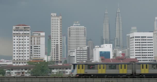 Άποψη του τρένου στο προσκήνιο και σύγχρονα κτίρια ουρανοξύστη στο παρασκήνιο. Κουάλα Λουμπούρ, Μαλαισία — Αρχείο Βίντεο
