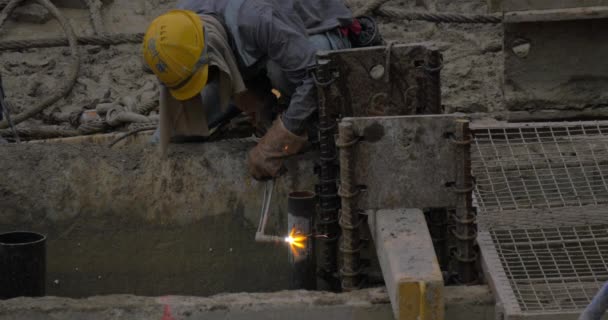 Рабочий, работающий с газовой струей для резки металлических труб — стоковое видео