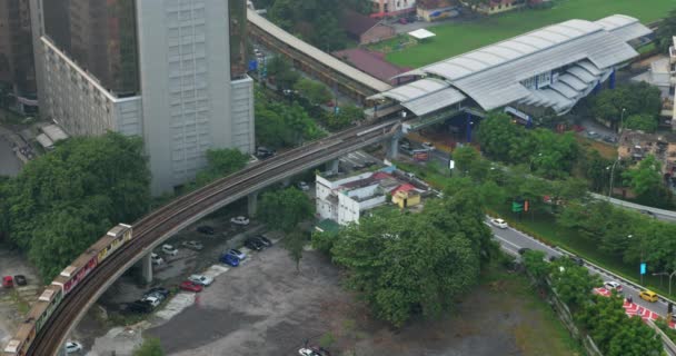 Vista a volo d'uccello delle ferrovie attraverso la strada contro il paesaggio urbano. Kuala Lumpur, Malesia — Video Stock