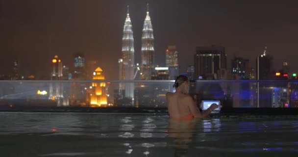 Mujer con almohadilla en la piscina de la azotea en Kuala Lumpur, Malasia — Vídeo de stock