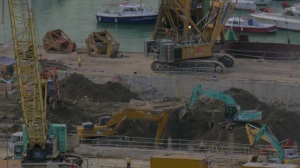 En Hong Kong, China están en obras de construcción excavadoras excavando terreno — Vídeo de stock