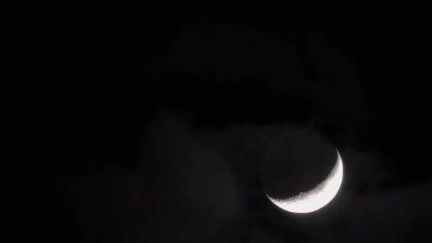 В ночном небе видны полумесяц и пасмурные облака — стоковое видео
