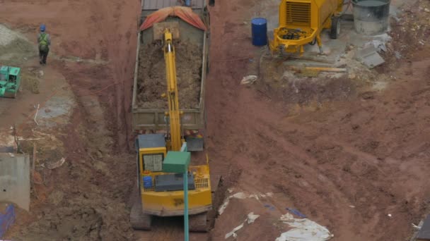 Bagger belädt LKW auf Baustelle — Stockvideo