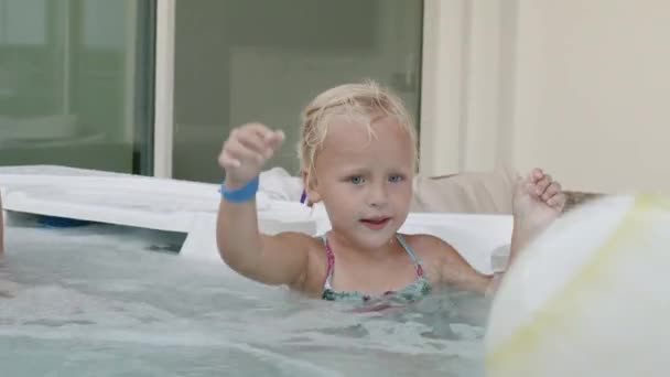 Niña disfrutando de un día divertido con la familia bañándose en bañera de hidromasaje — Vídeos de Stock