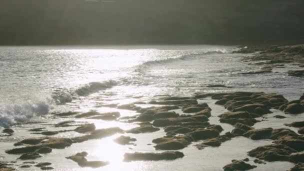 Okyanus dalgalarıyla dolu Lanzarote kıyıları volkanik taşları yıkıyor, günışığında sahne — Stok video