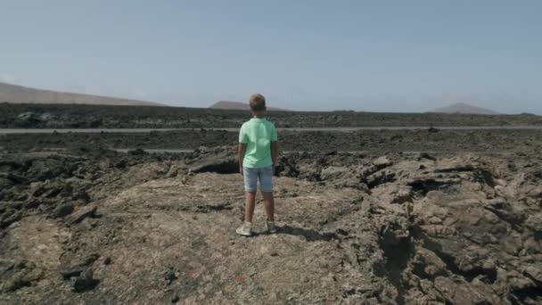 Barnet utforskar ett livlöst men pittoreskt landskap på Lanzarote — Stockvideo