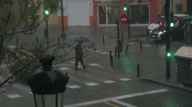 Valencia 'da sonbahar yağmuru. Yaşlı adam yürüyüşünü şemsiyenin altında bitirmek zorunda.