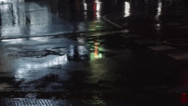 Bruine, flaques d'eau et lumières urbaines nocturnes réfléchissant sur la route — Video