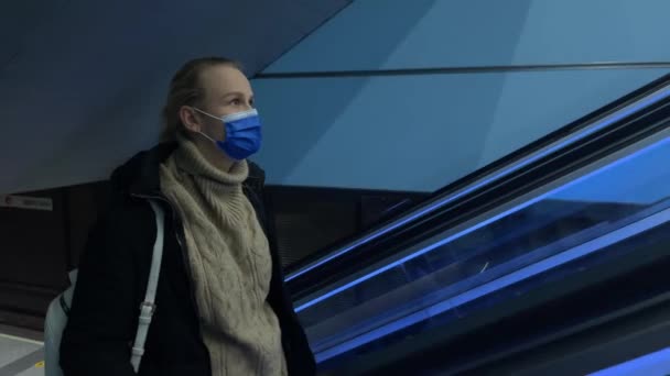 Μεταγωγέας με ιατρική μάσκα στις κυλιόμενες σκάλες στο μετρό — Αρχείο Βίντεο