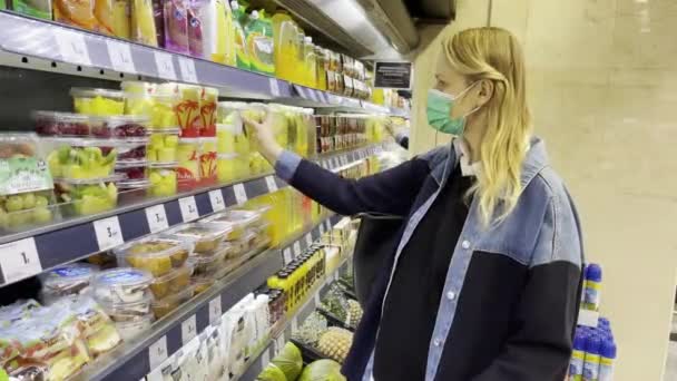 Mujer con máscara comprando frutas cortadas en el supermercado — Vídeos de Stock