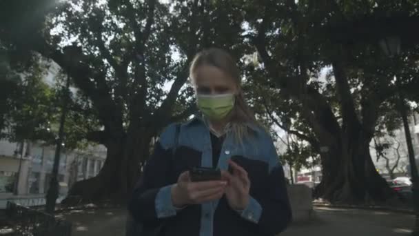Vrouw die op straat loopt zonder te kijken, behalve de telefoon. — Stockvideo