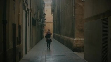 Busy woman alone in the street. She checking the time during the mobile talk