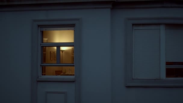 House window with dim light in the dusk — Stok video