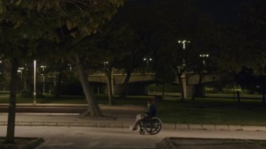 Engelli bir çocuğun boş bir parkta akşam gezintisi