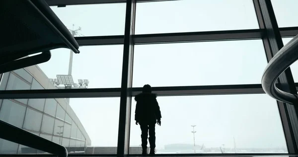 Child by the window and woman with suitcase — Stock Photo, Image