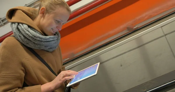 Donna sulla scala mobile utilizzando tablet — Foto Stock