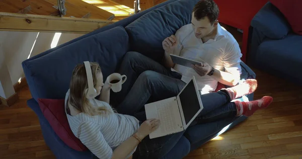 Чоловік і жінка вдома використовують майданчик і ноутбук — стокове фото