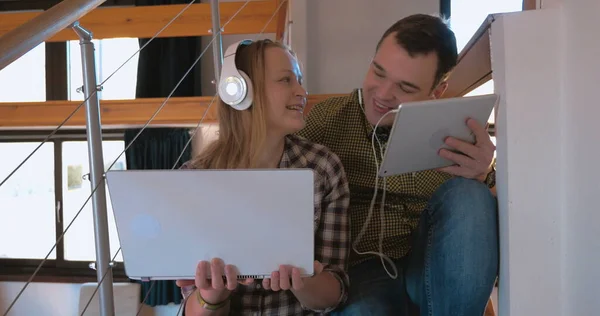 Young couple in heaphones at home enjoying music — Stock Photo, Image