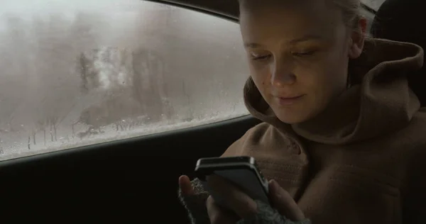 Woman using smartphone in the car — Stock Photo, Image