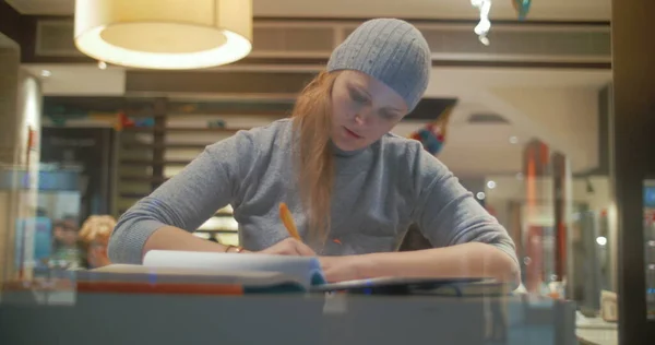 Mujer en la cafetería trabajando con almohadilla y tomando notas —  Fotos de Stock