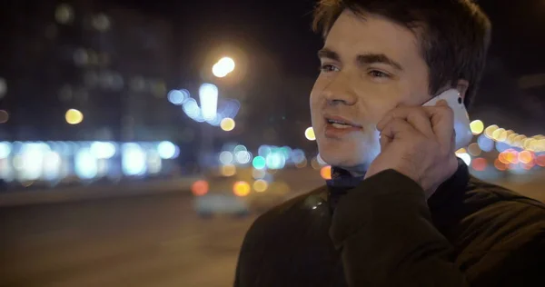 Egy férfi beszél telefonon az Esti utcában. — Stock Fotó