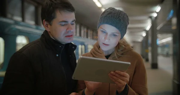 Young people discussing something using pad at metro station — Stock Photo, Image