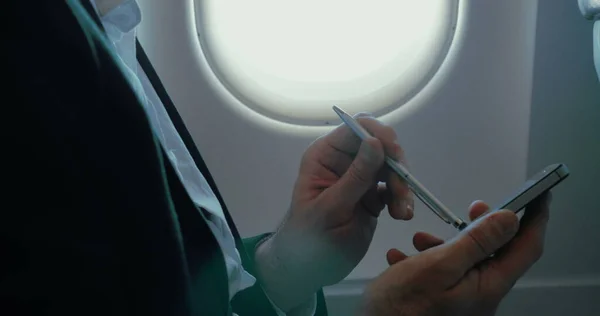 Homme d'affaires utilisant un téléphone intelligent pendant le vol — Photo